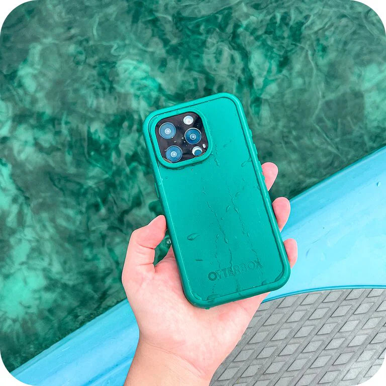 Hand holding a teal phone case with a blurred pool background