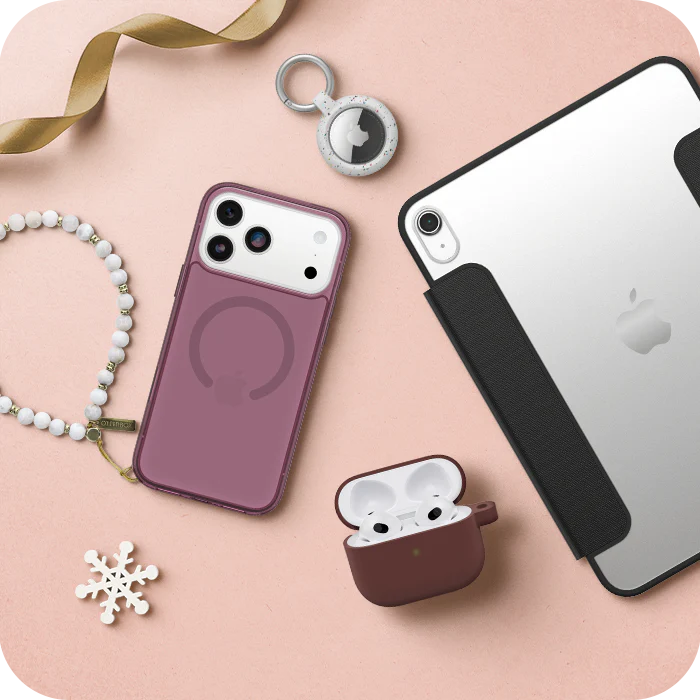 Smartphone, AirPods case, and accessories on a pink surface
