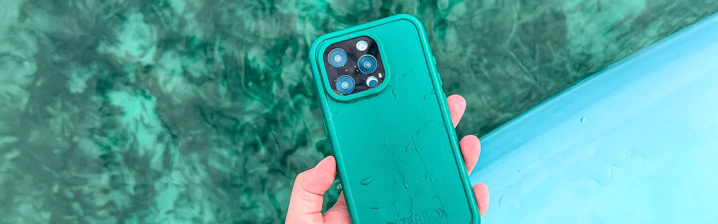 Person holding a teal phone case with a green marble background